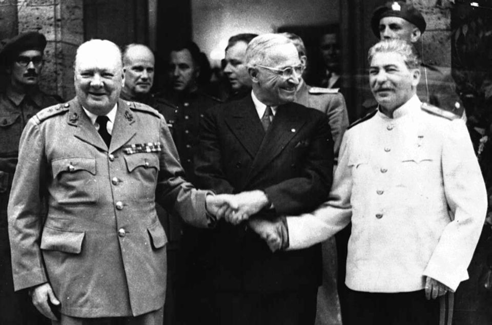 Les dirigeants des pays membres de la Grande alliance Winston Churchill, Joseph Staline et Harry Truman se serrent la main devant les photographes à Potsdam (Allemagne) en juillet 1945, en marge des négociations sur la configuration de l'Europe après la Seconde guerre mondiale
