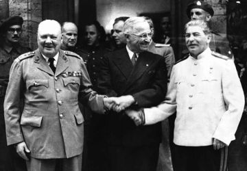 Les dirigeants des pays membres de la Grande alliance Winston Churchill, Joseph Staline et Harry Truman se serrent la main devant les photographes à Potsdam (Allemagne) en juillet 1945, en marge des négociations sur la configuration de l'Europe après la Seconde guerre mondiale