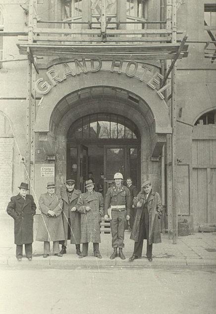At the entrance to the Grand Hotel in Nuremberg.  Second from the left is Soviet writer and journalist V. Vishnevsky, third from the left is Soviet director R. Karmen.  The Russian State Archives of Literature and Arts.
