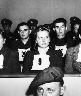 Irma Grese, leader of the women's Waffen SS at Belsen and assistant to Josef Kramer, the Beast of Belsen, seen wearing placard no. 9 on her chest, during the War Crime Trials at Lueneburg, Germany, Sept. 17, 1945. Wardens at Belsen Hertha Ehlert, wearing no. 8 and Ilse Lithe, no. 10, sit either side of Irma Grese.