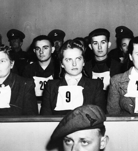 Irma Grese, leader of the women's Waffen SS at Belsen and assistant to Josef  Kramer, the Beast of Belsen, seen wearing placard no. 9 on her chest, during the War Crime Trials at Lueneburg, Germany, Sept. 17, 1945. Wardens at Belsen Hertha Ehlert, wearing no. 8 and Ilse Lithe, no. 10, sit either side of Irma Grese. 