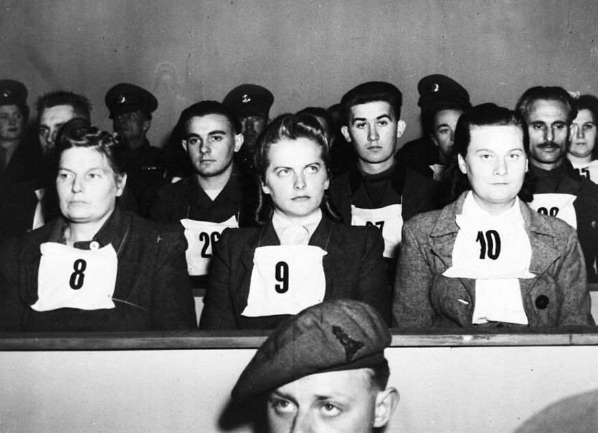 Irma Grese, leader of the women's Waffen SS at Belsen and assistant to Josef  Kramer, the Beast of Belsen, seen wearing placard no. 9 on her chest, during the War Crime Trials at Lueneburg, Germany, Sept. 17, 1945. Wardens at Belsen Hertha Ehlert, wearing no. 8 and Ilse Lithe, no. 10, sit either side of Irma Grese. 