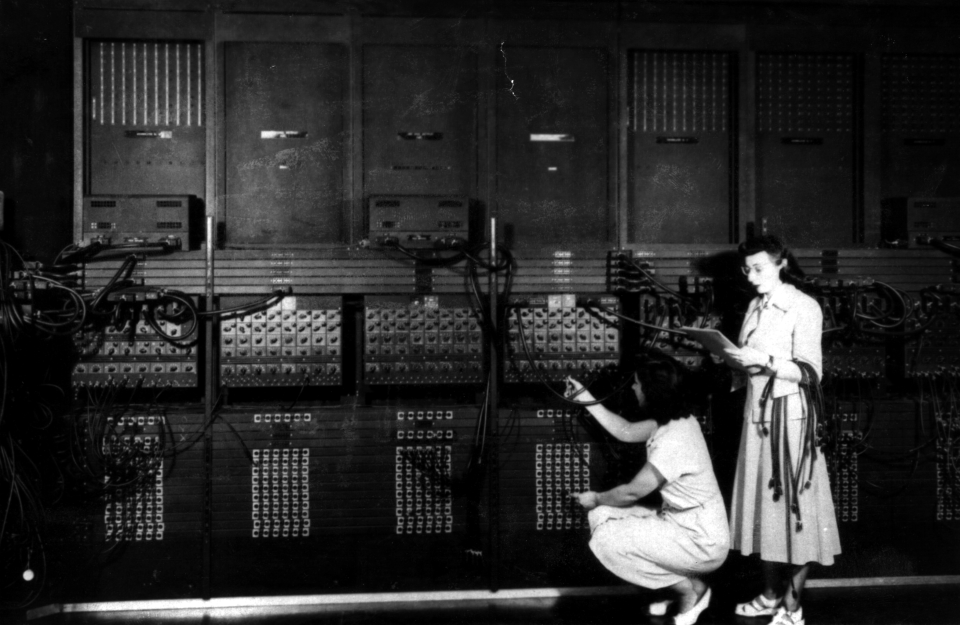 Six femmes sont devenues les premières programmeuses de l’ENIAC. Ruth Lichterman (accroupie) et Marlyn Wescoff (debout) câblent l’ENIAC avec un nouveau programme. 1946