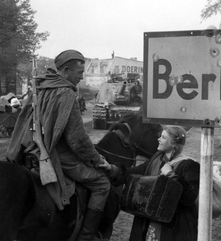 A Soviet soldier talks to a girl in Berlin. 1945  "General Berzarin's Last Act of Heroism" project. / Roman Carmen