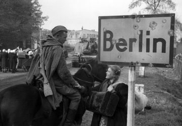 A Soviet soldier talks to a girl in Berlin. 1945  "General Berzarin's Last Act of Heroism" project. / Roman Carmen