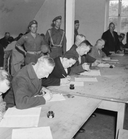  Suspected Nazis fill in a questionnaire about their political activities in a detention centre near Hamburg run by the British Army. Imperial War Museum Collection.