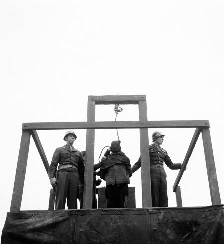 The noose is tightened around the hooded neck of Karl Willig, a nurse at the Hadamar Medical Institute, Germany, before the trap is sprung in the courtyard of the Bruchsal Prison, 14 March 1946. Willig and two others had been found guilty of murdering some 300 Polish and Russian prisoners of war by means of lethal injection. The other two were hanged the same morning.