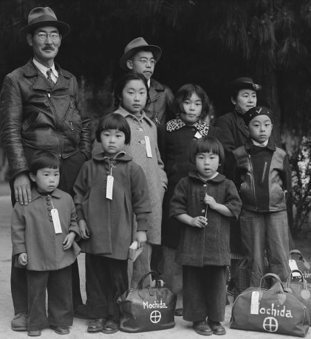 Des membres de la famille Mochida attendent le bus d’évacuation. Des étiquettes d’identification sont utilisées pour garder la cellule familiale intacte pendant toutes les phases d’évacuation.