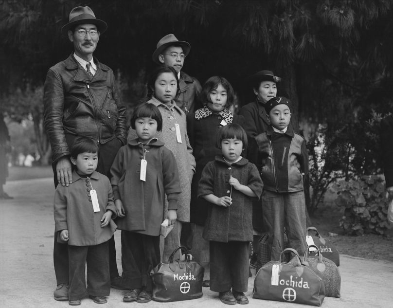Des membres de la famille Mochida attendent le bus d’évacuation. Des étiquettes d’identification sont utilisées pour garder la cellule familiale intacte pendant toutes les phases d’évacuation.