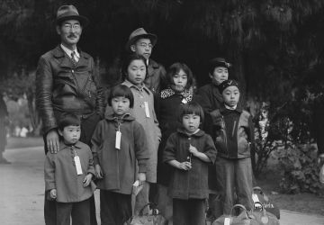 Des membres de la famille Mochida attendent le bus d’évacuation. Des étiquettes d’identification sont utilisées pour garder la cellule familiale intacte pendant toutes les phases d’évacuation.
