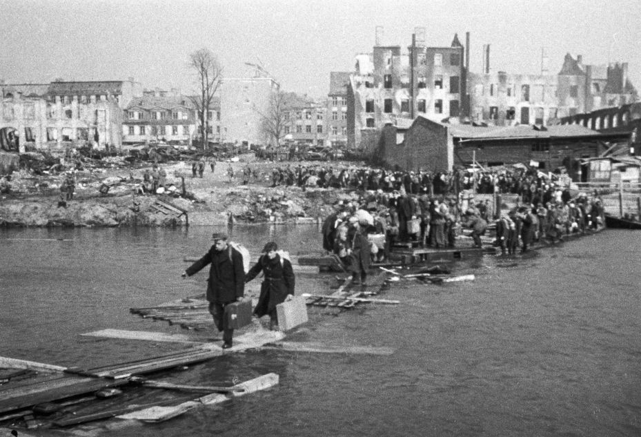 Residents of Königsberg cross the river using a wooden bridge as they return home on 9 April 1945