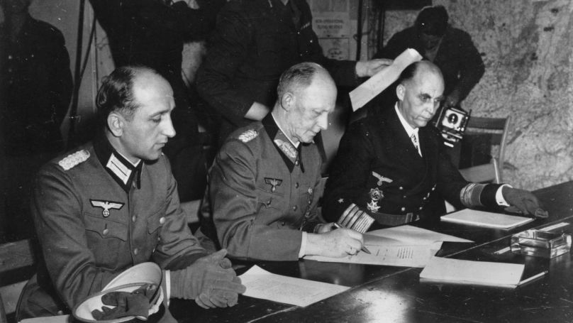 In this May 7, 1945 file photo, Gen. Alfred Jodl, center, signs the unconditional surrender of all armed German forces imposed by the Allied Powers, at Supreme Commander Eisenhowers headquarters in Reims, France. He is flanked by Gen. Wilhelm Oxenius, Commander of the German Luftwaffe, left, and General Admiral and Commander in Chief of the German fleet, Hans-Georg von Friedeburg, right. 