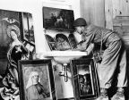 An American Soldier studies various paintings, one of them resting in a wash basin, May 29, 1945 in Germany. The paintings were part of the loot gathered from all parts of Europe by Hermann Goering. (AP Photo/H. N. Abrahams)