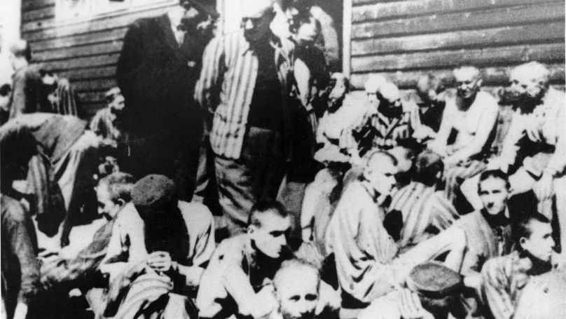 In this undated file photo, emaciated prisoners sit outside the hospital barrack in Nazi Germany's Mauthausen concentration camp during World War II. A German court has declined to put on trial a 95-year-old man alleged to have served as a guard at the Nazi’s Mauthausen concentration camp, saying Friday, Dec. 21, 2018, that it doesn’t see enough evidence to support charges of accessory to murder.