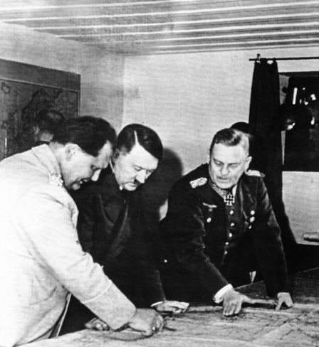 Adolf Hitler studiert mit Marschall Hermann Göring den Kriegsverlauf auf einer Karte an einem Ort, der von deutschen Quellen als Hitlers Hauptquartier an der Ostfront im Juli 1941 bezeichnet wurde. Marschall Wilhelm Keitel (rechts) schaut zu. Deutsche Quellen geben nicht an, wann dieses Bild gemacht wurde. Dieses wurde von Berlin nach New York am 21. April übermittelt.