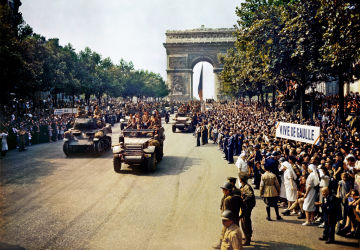 Foule sur les Champs Élysées regardant les blindés de la 2e DB avec des banderoles «De Gaulle au pouvoir» et «Vive De Gaulle», le 26 août 1944.