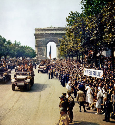 Crowds of French patriots line the Champs Elysees watch as Free French tanks and half-tanks of General Leclerc's 2nd Armoured Division pass through the Arc de Triomphe during the liberation of Paris on 26 August 1944. Among the crowd can be seen banners in support of Charles de Gaulle.