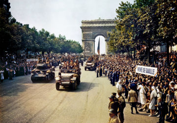 Crowds of French patriots line the Champs Elysees watch as Free French tanks and half-tanks of General Leclerc's 2nd Armoured Division pass through the Arc de Triomphe during the liberation of Paris on 26 August 1944. Among the crowd can be seen banners in support of Charles de Gaulle.