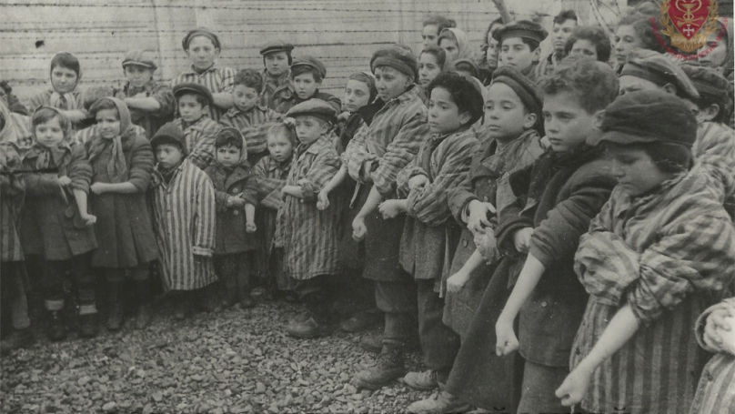 Children at a concentration camp wait for their blood to be taken by Nazi doctors
