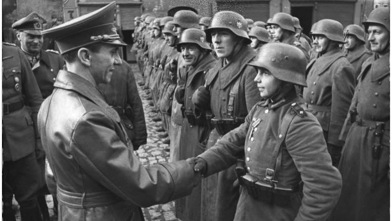 Goebbels presents the Iron Cross to 16-year-old Hitler Youth fighter Willie Huebner after the battle at Lauban, March 1945. // Bundesarchiv, Bild 183-J31305 / CC-BY-SA 3.0 