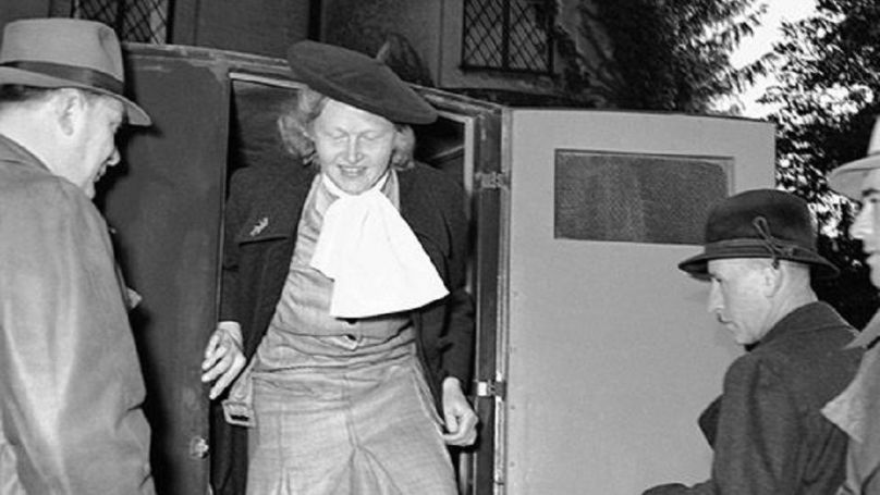 Ilsa Koch sort d’une voiture de police devant la prison pour femmes d"Eichach à Augsbourg, Allemagne, le 17 octobre 1949 