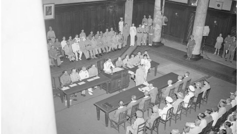 General Itagaki Seishiro signing surrender document at surrender ceremony of the Japanese to the Allies in municipal building (City Hall), 12 September 1945