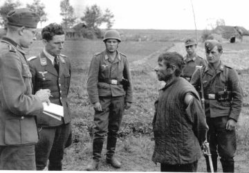 Des nazis interrogeant un partisan soviétique, été 1942, district de Kholmskiy, région de Novgorod.