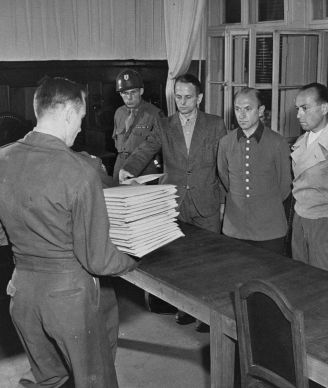 Les accusés (de gauche à droite: Otto Ohlendorf, Heinz Jost, Erich Naumann et Erwin Schulz) reçoivent les actes d'accusation. Juillet 1947 / USHMM