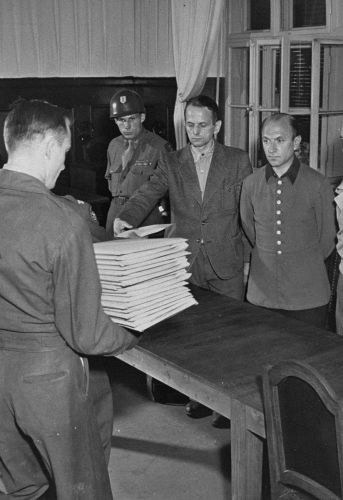 Les accusés (de gauche à droite: Otto Ohlendorf, Heinz Jost, Erich Naumann et Erwin Schulz) reçoivent les actes d'accusation. Juillet 1947 / USHMM
