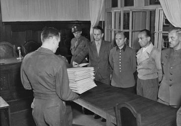 Les accusés (de gauche à droite: Otto Ohlendorf, Heinz Jost, Erich Naumann et Erwin Schulz) reçoivent les actes d'accusation. Juillet 1947 / USHMM