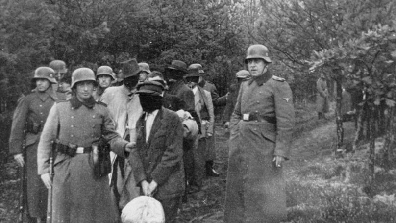 Blindfolded civilians led to a place of execution in the woods