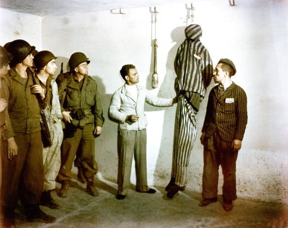 D'anciens détenus de Buchenwald font une démonstration de crochets de suspension et d'autres dispositifs de torture à des soldats américains. Ardean R. Miller.