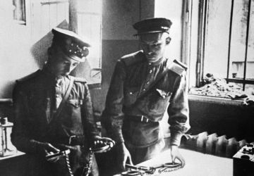Des soldats soviétiques examinent des instruments de torture dans la prison de la Gestapo à Berlin, 1er juin 1945. 