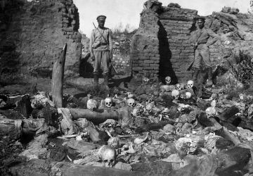 Des soldats russes sur les restes d'Arméniens brûlés vifs dans le village de Sheikhalan, 1915.