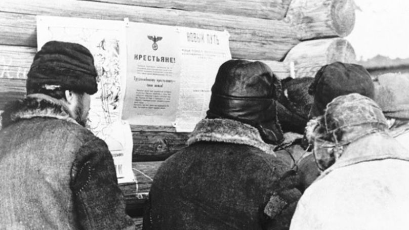 Des paysans lisant les ordonnances agraires allemandes, 1942.